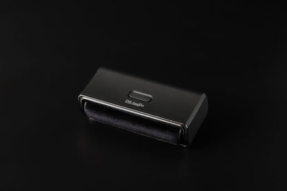 DS Audio SC-001 : brosse sonique noire vue de trois quarts, fibres et bouton de mise en marche visibles.